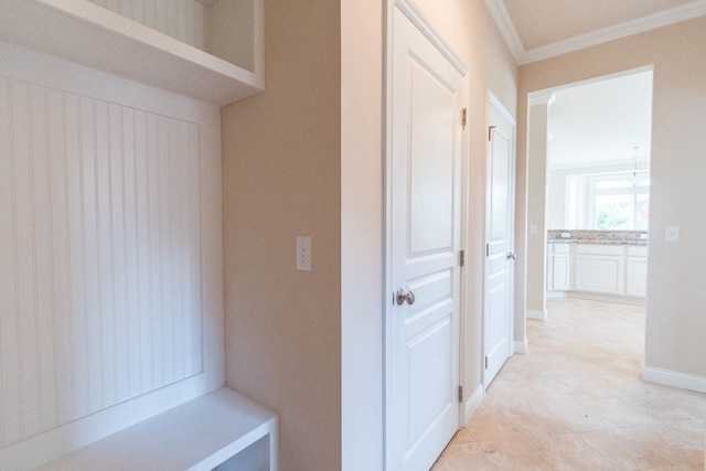 hall with ornamental molding and light tile patterned floors