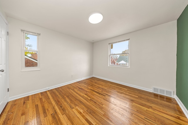 empty room with wood-type flooring and a wealth of natural light