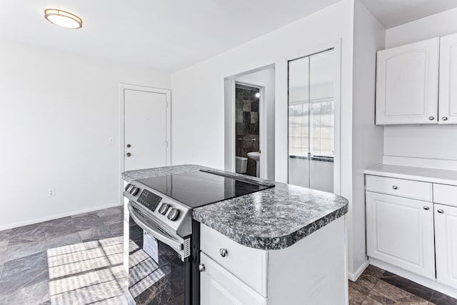 kitchen featuring stainless steel electric range, a kitchen island, and white cabinetry