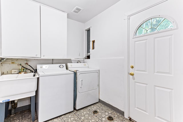 laundry room featuring washing machine and dryer and cabinets