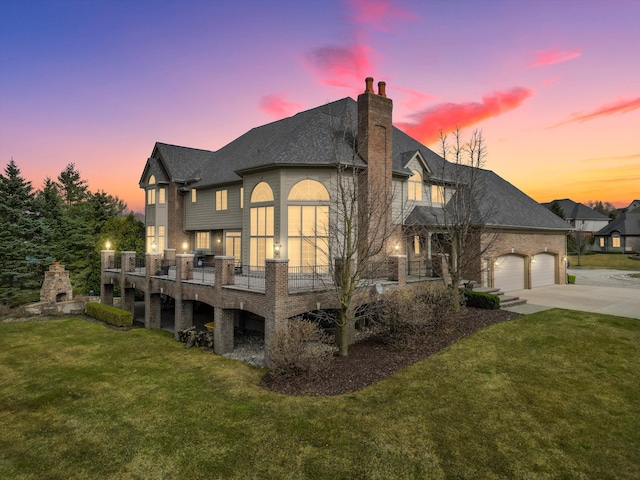 back house at dusk with a yard and a garage