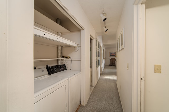 clothes washing area featuring washer and dryer, light colored carpet, and rail lighting