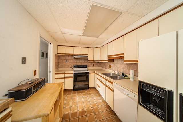 kitchen with backsplash, a drop ceiling, white appliances, and sink