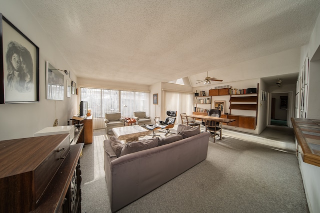 living room featuring ceiling fan, a textured ceiling, light carpet, and vaulted ceiling