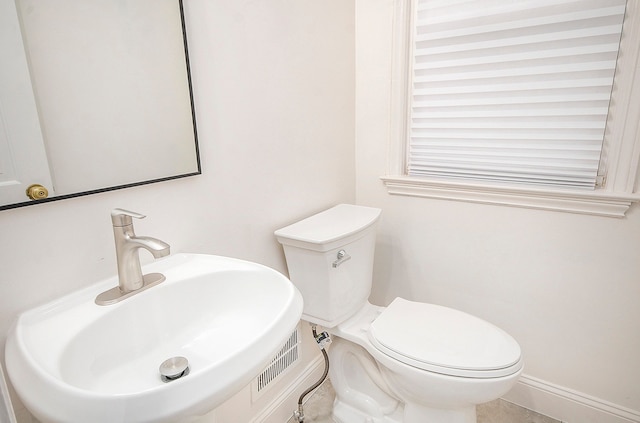 bathroom featuring tile patterned flooring, toilet, and sink