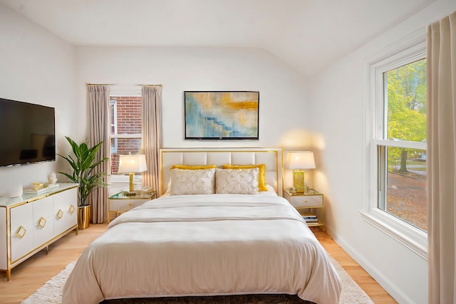 bedroom with light hardwood / wood-style flooring and lofted ceiling