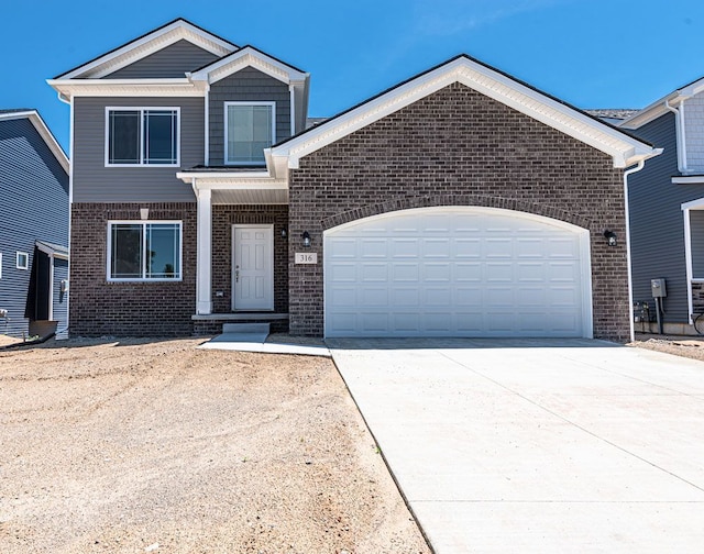 view of front of house featuring driveway, an attached garage, and brick siding