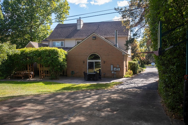 back of property featuring a yard and a patio