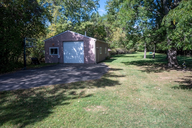 view of yard with a garage and an outbuilding