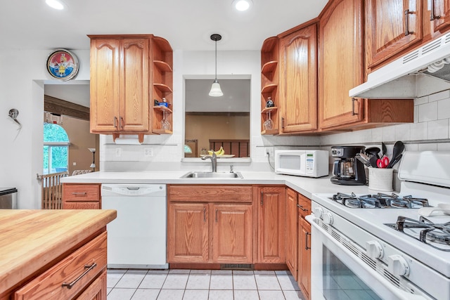 kitchen featuring white appliances, sink, light tile patterned floors, tasteful backsplash, and decorative light fixtures