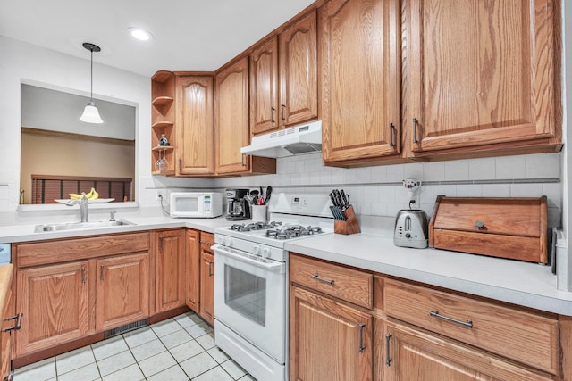 kitchen with backsplash, white appliances, sink, hanging light fixtures, and light tile patterned flooring