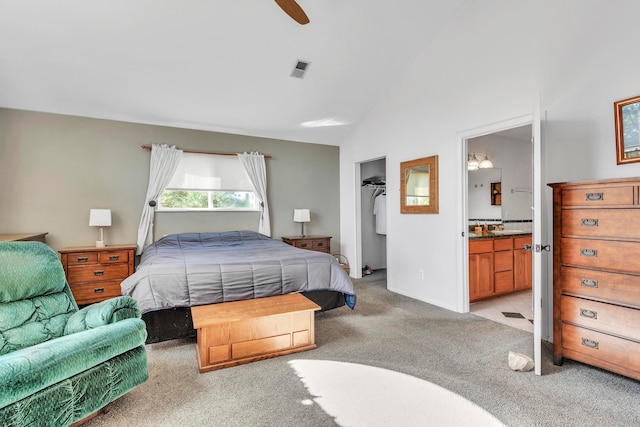 bedroom featuring a walk in closet, light carpet, connected bathroom, and a closet