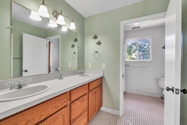 bathroom with tile patterned flooring, vanity, and toilet