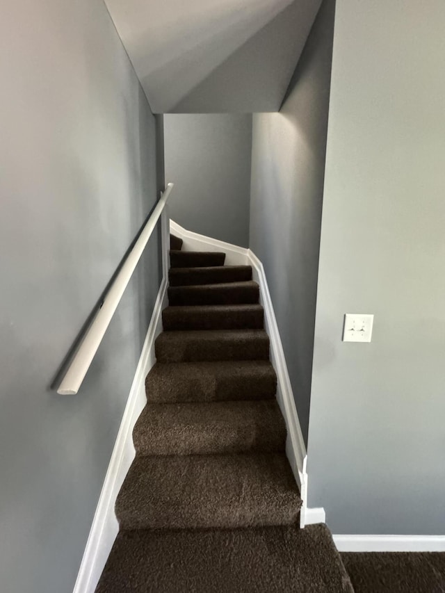 stairway with lofted ceiling and carpet