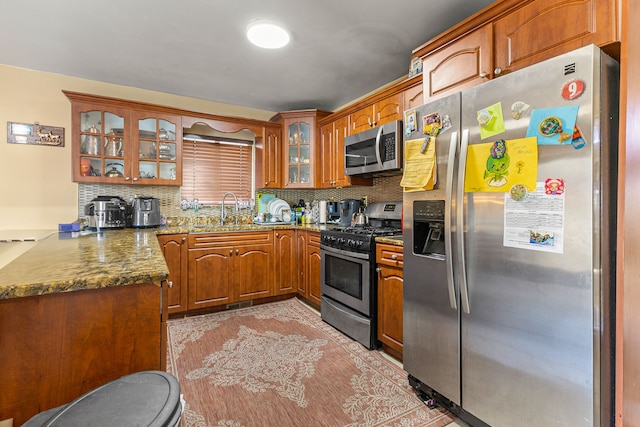 kitchen featuring dark stone counters, sink, appliances with stainless steel finishes, and tasteful backsplash