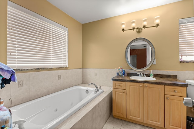 bathroom featuring tile patterned floors, vanity, and a relaxing tiled tub