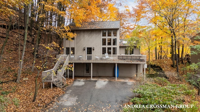 4719 Fox Hill Ln, Macatawa, MI 49434 - rear view of property featuring an attached garage, stairs, driveway, and a deck