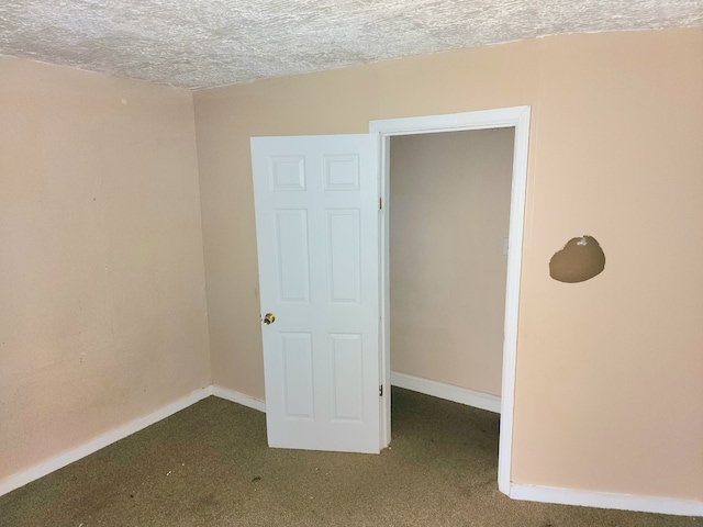 carpeted spare room featuring a textured ceiling