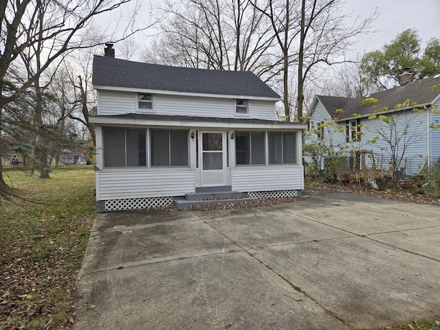 25438 4th St, Grosse Ile, MI 48138 - view of front of house with a sunroom, a chimney, and a shingled roof