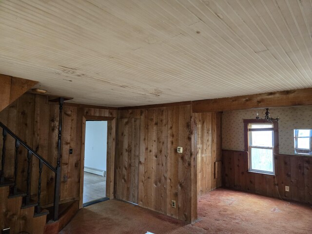 25438 4th St, Grosse Ile, MI 48138 - carpeted empty room with wood walls, a baseboard radiator, wood ceiling, stairs, and wainscoting