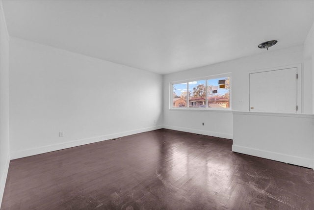 spare room featuring dark wood-type flooring