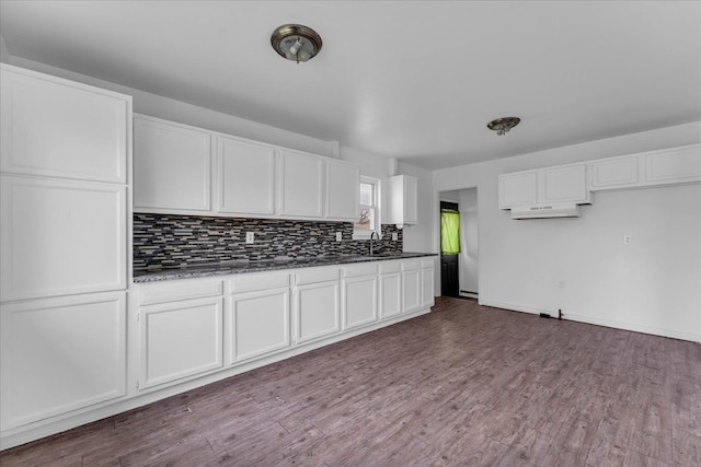 kitchen with hardwood / wood-style floors, white cabinetry, and sink