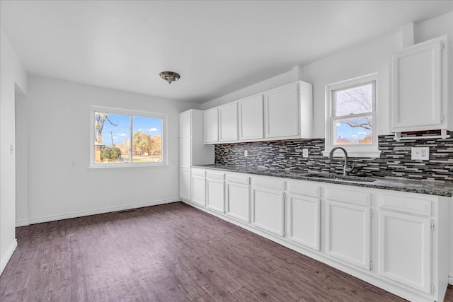 kitchen with plenty of natural light, dark hardwood / wood-style flooring, white cabinetry, and sink