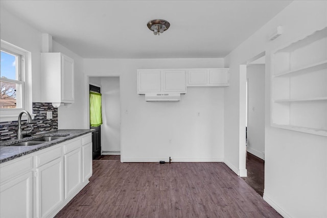 kitchen featuring white cabinets, sink, dark stone counters, and dark wood-type flooring