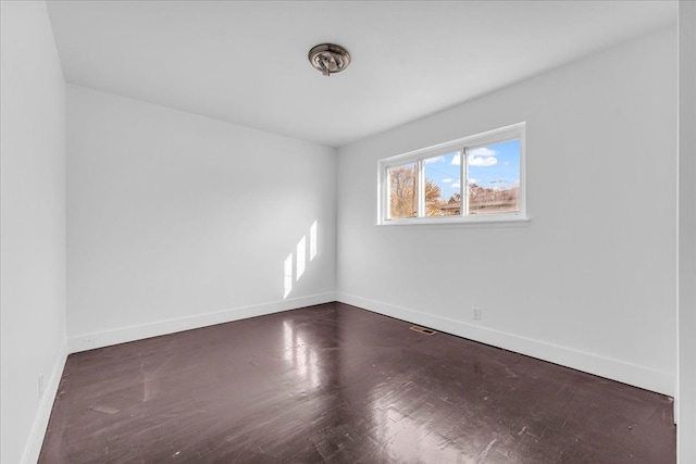 unfurnished room with dark hardwood / wood-style flooring