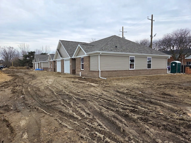 18750 14 Mile Rd, Roseville, MI 48066 - view of side of property featuring brick siding, a garage, and roof with shingles