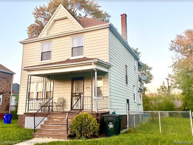 view of front property featuring covered porch and a front lawn