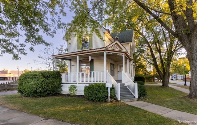 view of front of property with covered porch and a front yard