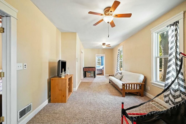 bedroom with ceiling fan, light colored carpet, and multiple windows