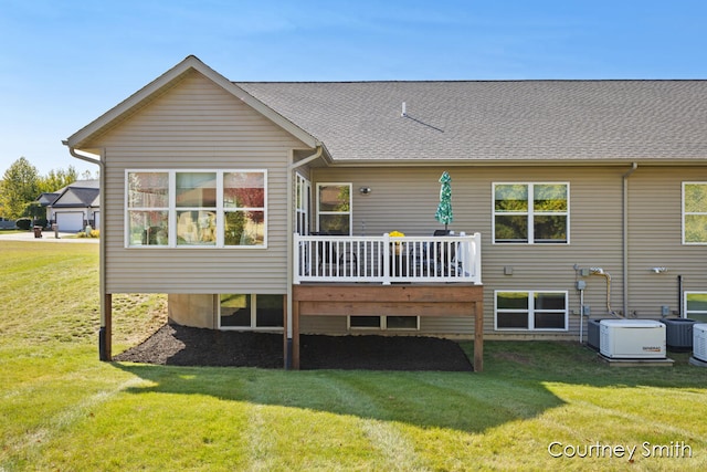 rear view of house featuring a lawn, central AC, and a deck