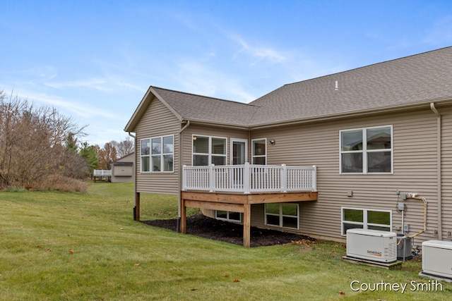 rear view of property featuring a lawn and a deck