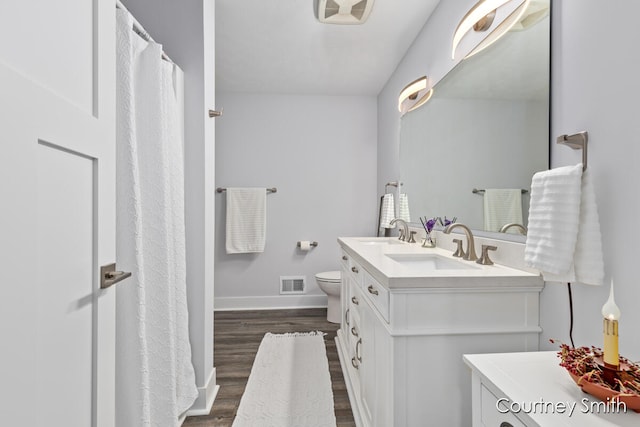 bathroom with toilet, vanity, and hardwood / wood-style flooring