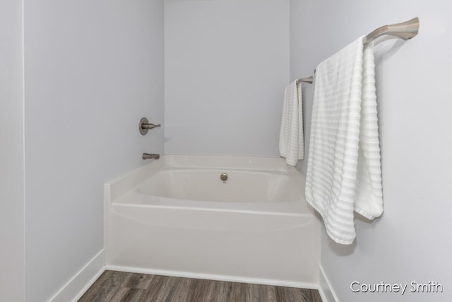 bathroom featuring a tub to relax in and hardwood / wood-style flooring