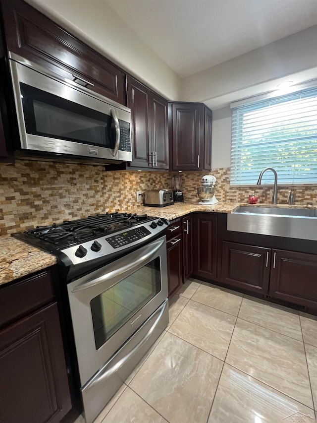 kitchen featuring decorative backsplash, sink, dark brown cabinetry, and stainless steel appliances