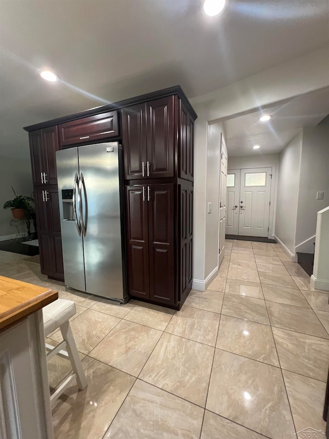 kitchen featuring dark brown cabinets and stainless steel fridge