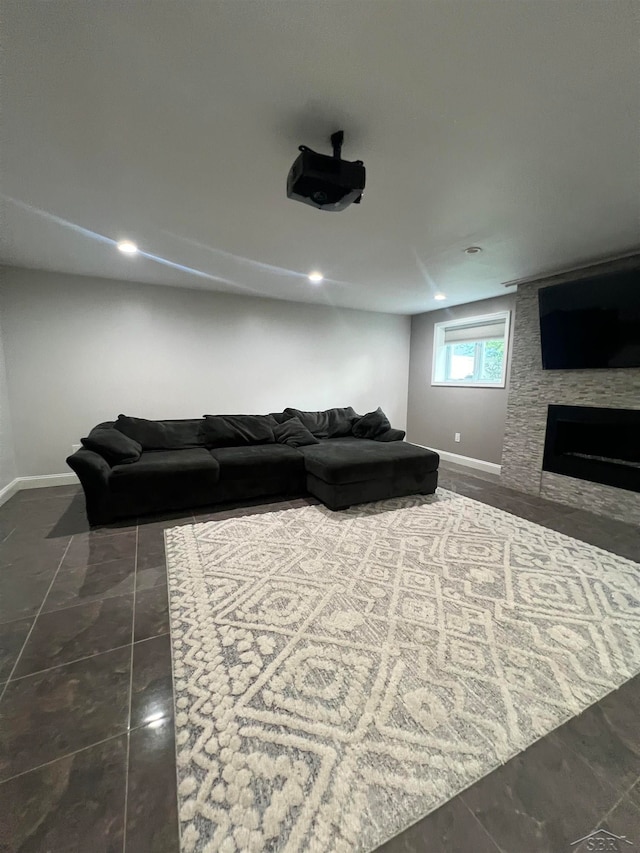 living room with dark tile patterned flooring and a large fireplace