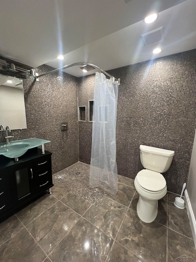 bathroom featuring a shower with shower curtain, vanity, toilet, and tile walls