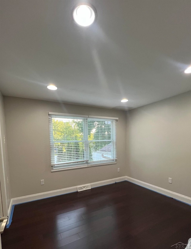 unfurnished room with dark hardwood / wood-style flooring