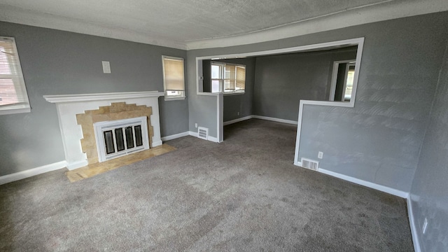 unfurnished living room featuring plenty of natural light, dark carpet, and a textured ceiling