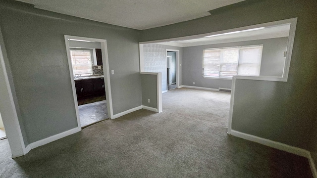 empty room with carpet flooring and a healthy amount of sunlight