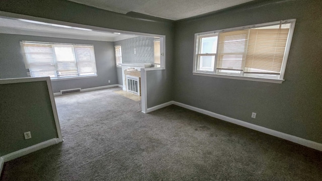 carpeted spare room featuring a textured ceiling and plenty of natural light