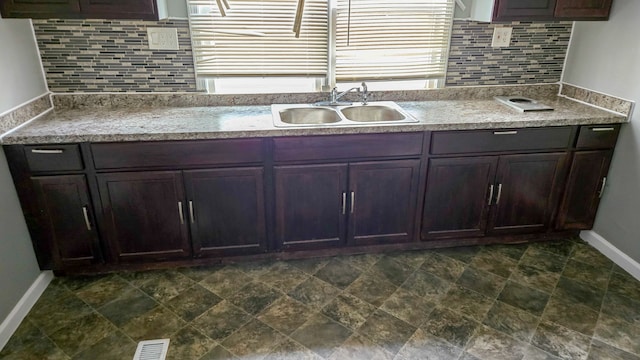 kitchen featuring backsplash, sink, and dark brown cabinets