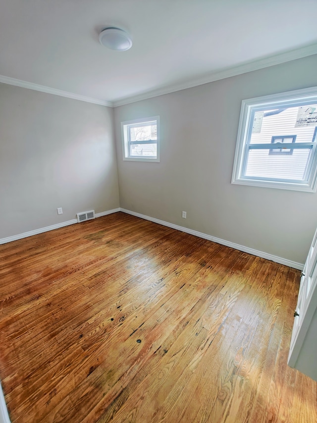 unfurnished room with light hardwood / wood-style flooring and crown molding