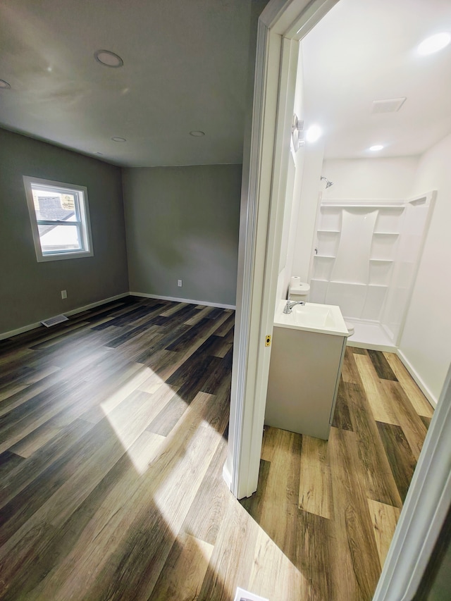 bathroom featuring a shower, wood-type flooring, and vanity