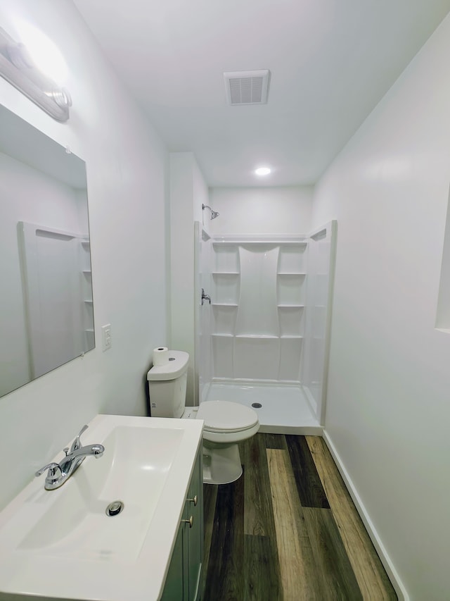 bathroom with walk in shower, toilet, vanity, and hardwood / wood-style flooring