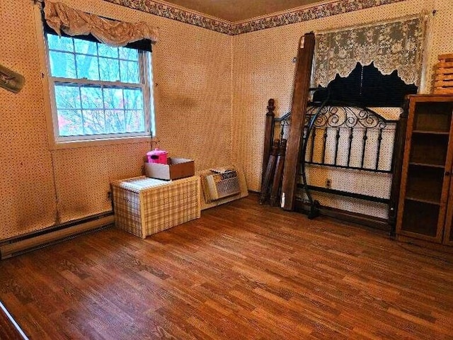 bedroom with hardwood / wood-style flooring, a wall mounted air conditioner, ornamental molding, and a baseboard heating unit